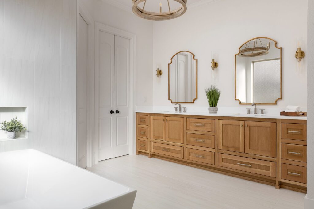 Freestanding tub beside a white oak double vanity in an Argyle primary bathroom