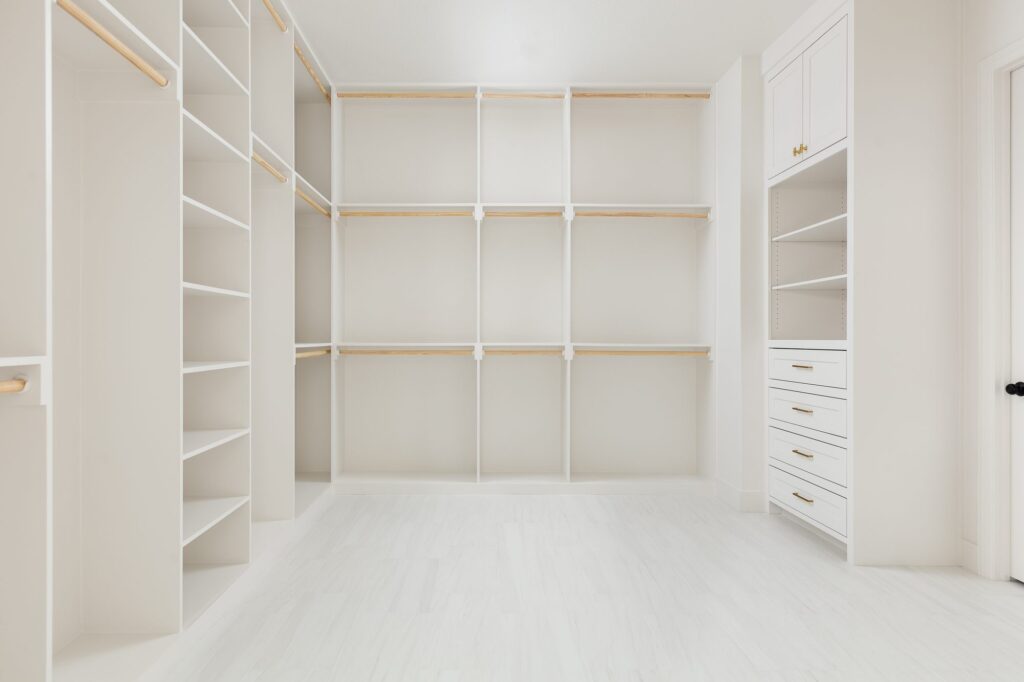 Custom primary closet with open shelving and drawers