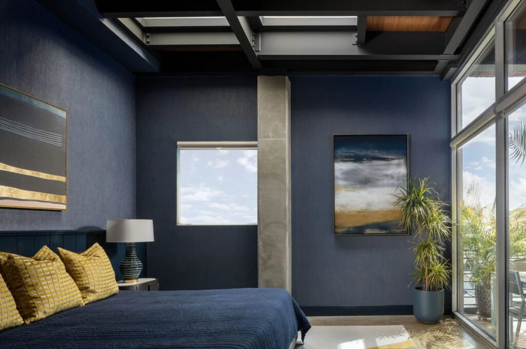 Navy primary bedroom with beamed ceiling and city view in a remodeled Dallas condo
