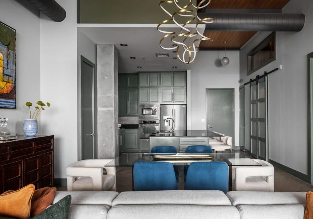 Open dining and kitchen view with sculptural chandelier in a whole-home condo remodel